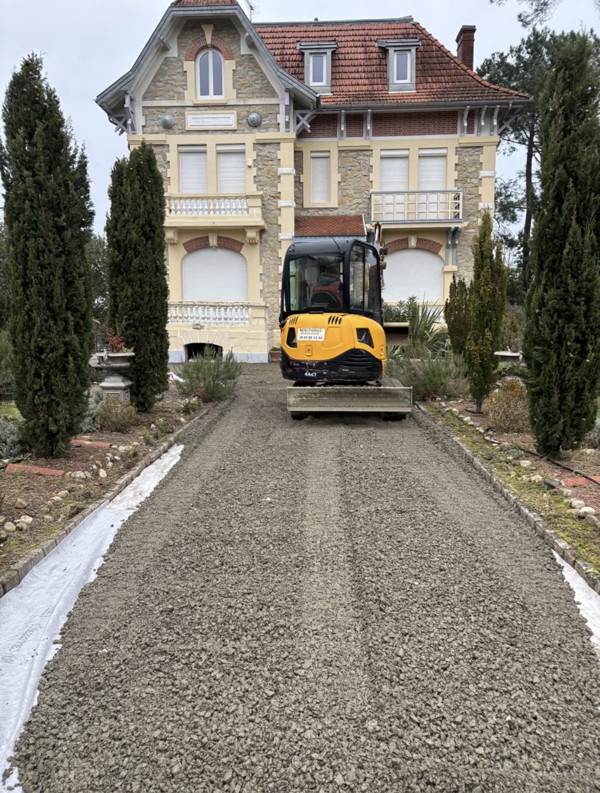 Allée décaissée avant travaux, fond de forme en grave réglé à la mini-pelle, géotextile visible en rive